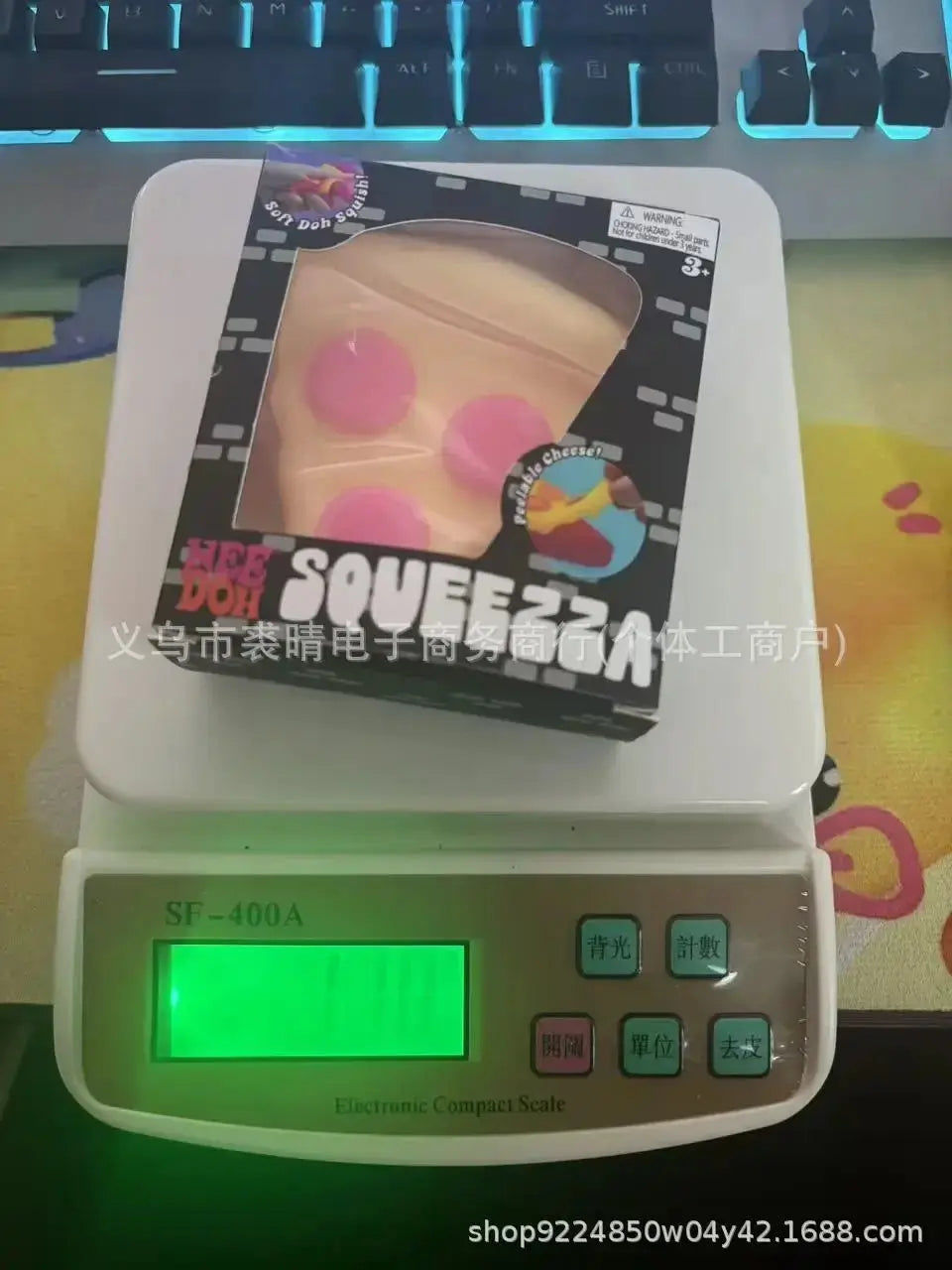 包装盒中的披萨片挤压减压玩具，黄色奶酪配粉色圆点
